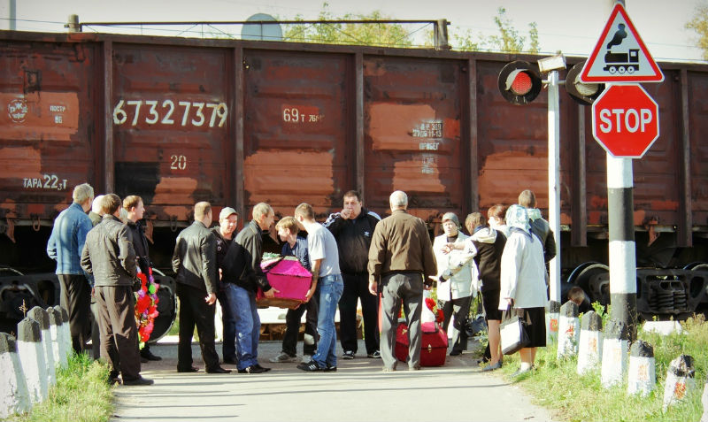 Жители российского города с гробами пролезают под поездом, чтобы попасть на кладбище